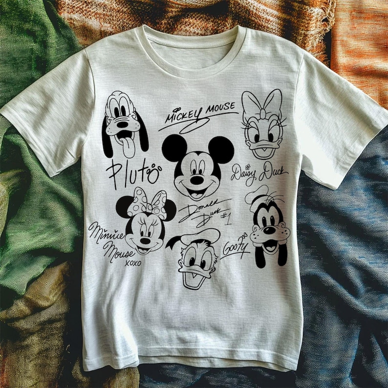 May include: White t-shirt with black and white illustrations of Mickey Mouse, Minnie Mouse, Pluto, Goofy, Donald Duck, and Daisy Duck. Each character has their signature underneath. The text reads "Mickey Mouse", "Pluto", "Minnie Mouse XOXO", "Donald Duck #1", "Goofy", and "Daisy Duck".