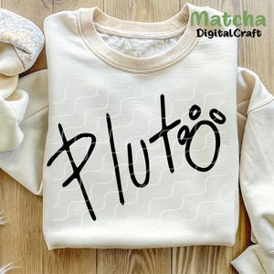 Puede incluir: Una sudadera blanca con la palabra "Pluto" escrita en letra negra con una huella de pata al lado.