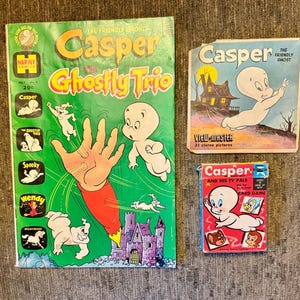 以下が含まれることがあります： ヴィンテージのキャスパー・ザ・フレンドリー・ゴーストのコレクション。漫画「キャスパーとゴーストトリオ」、ビューマスターのパッケージ、カードゲームの箱が含まれています。漫画は、キャスパーと他のキャラクターが描かれた緑色の背景です。