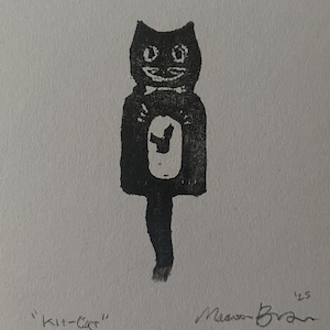 May include: A black and white block print illustration of a stylized cat clock with a long tail. The cat has a white oval on its chest and a bow tie. The text "Kit-Cat" is printed on the bottom left, and the signature with "'25" is on the bottom right.