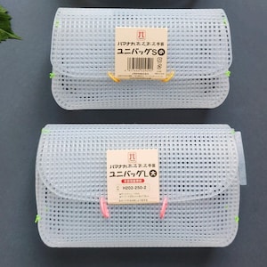 May include: Two white mesh pouches with rounded edges are shown. The top pouch is smaller and labelled "ユニバッグS". The bottom pouch is larger and labelled "ユニバッグL". Both have tags with Japanese text and are secured with yellow and pink ties.
