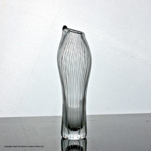 May include: A clear glass vase with a textured, ribbed design. The vase has a narrow opening and a wide base.