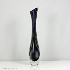 Könnte beinhalten: Eine hohe, schlanke Glasvase mit einem dunkelblauen Körper und vertikalen silbernen Streifen. Die Vase hat einen abgerundeten Boden und eine schmale Öffnung.