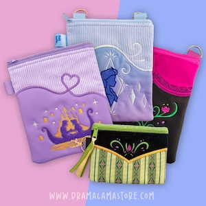Puede incluir: Cuatro estuches rectangulares con cremallera y diseños bordados. Uno es de color morado claro con un castillo dorado, uno azul claro con una silueta, uno negro y rosa con bordados florales y un estuche pequeño de rayas verdes y negras.