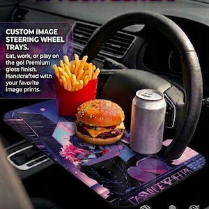 Könnte beinhalten: Ein individuelles Lenkradtablett mit Burger, Pommes und einer Getränkedose. Das Tablett hat eine hochwertige Hochglanzoberfläche und ein farbenfrohes Design im Anime-Stil. Auf dem Tablett steht "UPGRADE YOUR RIDE & YOUR LUNCH!" und "CUSTOM IMAGE STEERING WHEEL TRAYS."