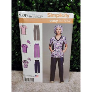 Puede incluir: Patrón de costura Simplicity 1020 BB, con una mujer con una blusa y un pantalón con estampado floral. El patrón incluye varios diseños de blusas y pantalones, con tallas que van de la 46 a la 54. El paquete tiene el texto "easy-to-sew".