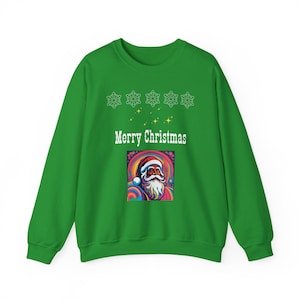 Può includere: Maglione di Natale verde con un motivo a fiocco di neve bianco e il testo "Buon Natale". Un'illustrazione colorata di Babbo Natale si trova al centro del maglione.