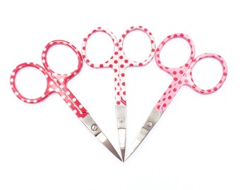 Könnte beinhalten: Drei Paare kleiner, roter und rosa Scheren mit weißen Punkten. Die Scheren haben silberne Klingen.