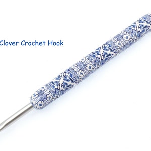 Peut inclure: Un crochet avec un manche à motifs bleus et blancs, étiqueté 'Clover Crochet Hook'.