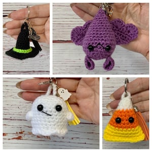 Op de afbeelding: Een set van vijf gehaakte sleutelhangers met Halloween-thema. De sleutelhangers omvatten een heksenhoed, een spook, een vleermuis, een snoepmais en een spookbedel.