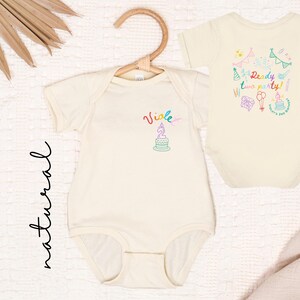 May include: Two natural-colored baby bodysuits. The left bodysuit features the name Violet and a birthday cake graphic. The right bodysuit displays the text Ready two party! surrounded by colorful illustrations of party hats, balloons, and gifts.