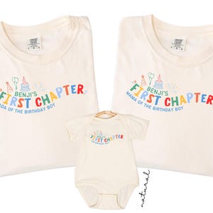May include: Two ivory t-shirts and one natural-colored baby bodysuit. The shirts feature colorful text reading Benji's First Chapter, with Dada of the Birthday Boy on one and Mama of the Birthday Boy on the other, plus birthday graphics.