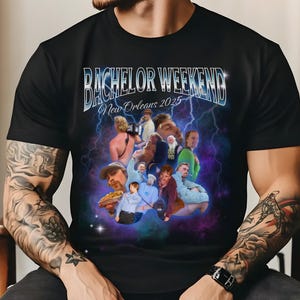 May include: Black t-shirt with a graphic print of a group of men in a party setting. The text "Bachelor Weekend New Orleans 2025" is printed on the shirt.