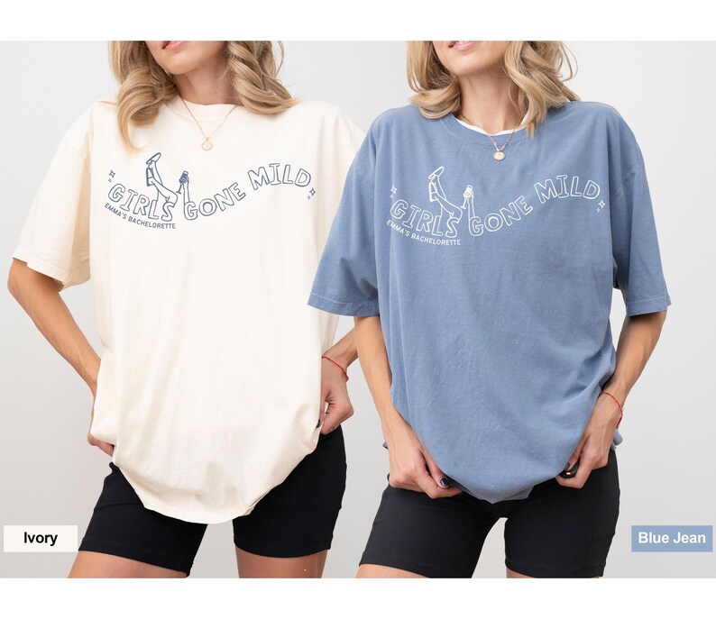 May include: Two oversized t-shirts in ivory and blue jean colors, each featuring a graphic print of legs in the air with the text "GIRLS GONE MILD" and "EMMA'S BACHELORETTE" in a curved layout, paired with black shorts.