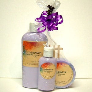May include: A gift set of lavender-scented goat milk lotion, soap, and body butter. The products are packaged in a clear plastic bag with a purple ribbon. The labels on the bottles and jars feature a watercolor design of lavender flowers.