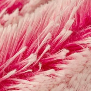 May include: Close-up of a pink and white fuzzy fabric with a soft, fluffy texture.