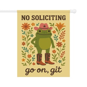 May include: A decorative garden flag with a cartoon frog wearing a cowboy hat and boots. The flag has the text "NO SOLICITING" and "go on, git" in brown lettering. The background is a light yellow with floral accents.