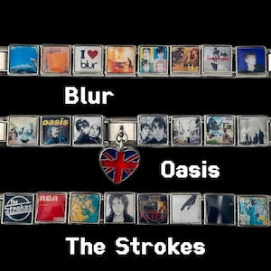 May include: A collection of silver charm bracelets featuring album art from the bands Blur, Oasis, and The Strokes. A heart-shaped charm with a Union Jack design hangs from the Oasis bracelet. The band names are displayed in white text.