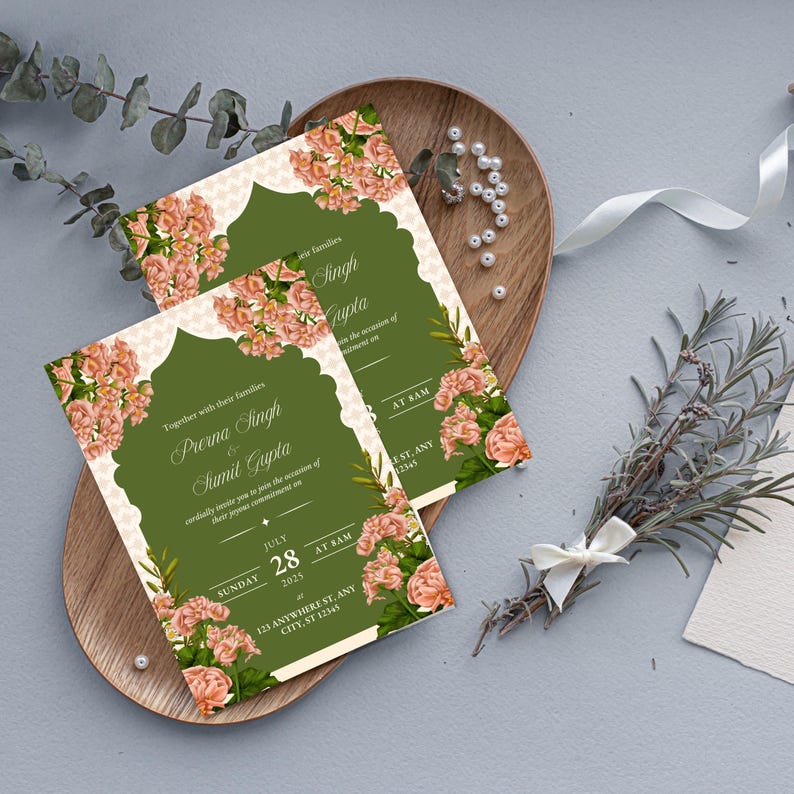 May include: Two wedding invitations with floral designs. The invitations feature a green background with peach-colored flowers and decorative borders. The text includes names, dates, and addresses. The invitations are on a wooden tray with decorative elements.
