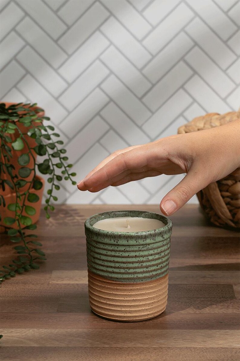 Reusable ceramic candle jar in green and tan with a hand-poured non-toxic soy wax refill. Ideal for eco-conscious gift giving.