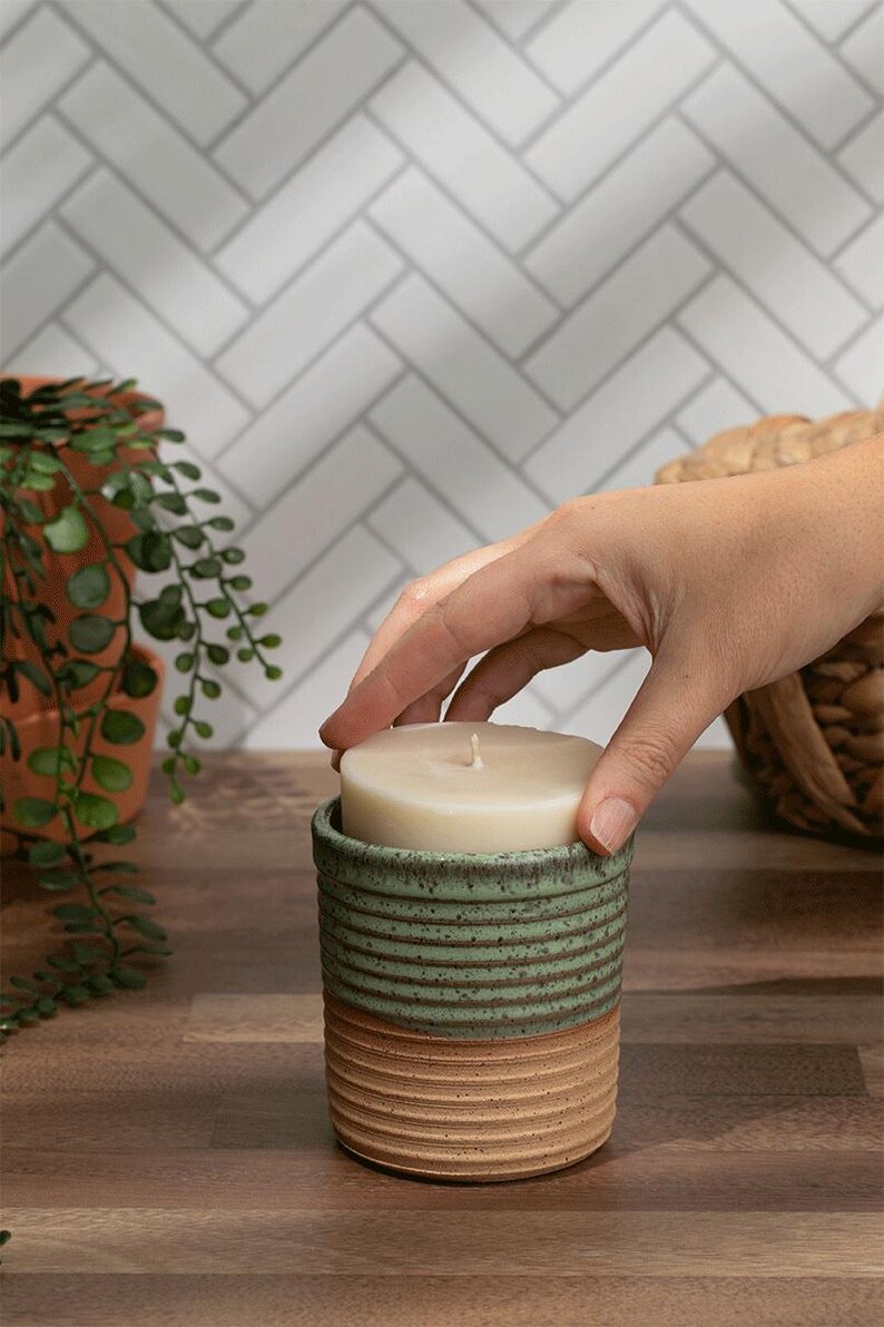 Eco-friendly refillable candle in a green and tan ceramic jar with a no-mess soy wax refill. Perfect for modern sustainable living.