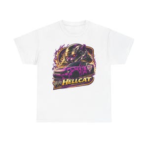 May include: White t-shirt featuring a graphic of a race car with a driver in a helmet, flames, and the word "HELLCAT" in gold. The car is purple and black. A checkered flag is at the bottom.