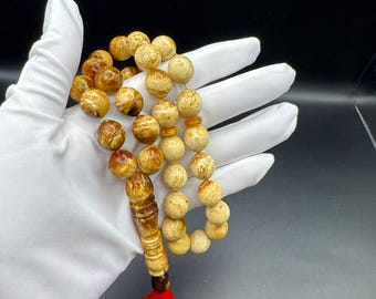 Handgemaakte tasbih van geperste Baltische barnsteen: moslimgebedkralen met 33 kralen en rood kwastje