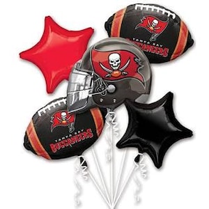 Puede incluir: Conjunto de cinco globos con temática de los Tampa Bay Buccaneers. Incluye dos globos de fútbol, un globo de casco y dos globos de estrella. Una estrella es roja y la otra es negra.