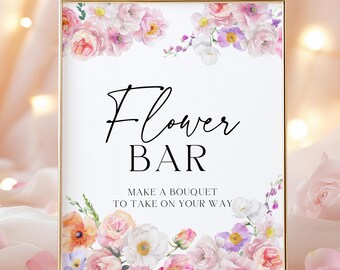 May include: A white sign with a gold frame and floral border. The sign says "Flower Bar" and "Make a bouquet to take on your way".