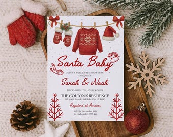 Peut inclure: Une invitation de baby shower sur le thème de Noël avec le texte "Santa Baby" en écriture rouge. L'invitation présente des illustrations de vêtements de fête suspendus à une corde à linge. L'invitation est sur fond blanc avec des accents rouges.