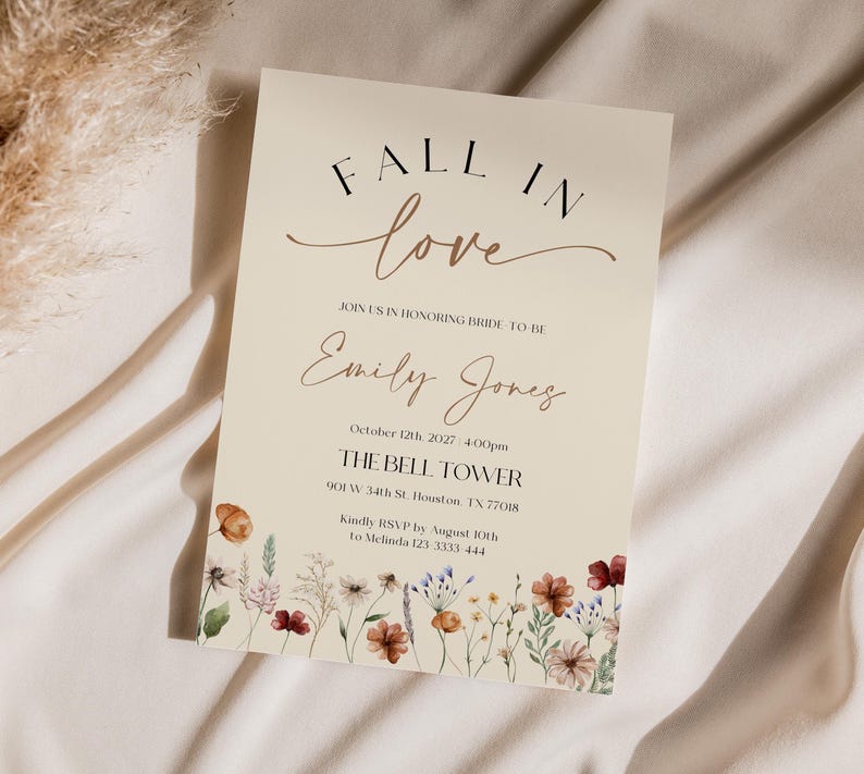 Fall in Love" bridal shower invitation with modern calligraphy, autumn wildflowers border, and minimalist neutral background.