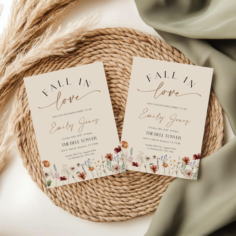 Fall in Love" bridal shower invitation with modern calligraphy, autumn wildflowers border, and minimalist neutral background.