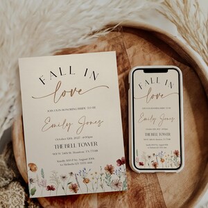 Fall in Love" bridal shower invitation with modern calligraphy, autumn wildflowers border, and minimalist neutral background.