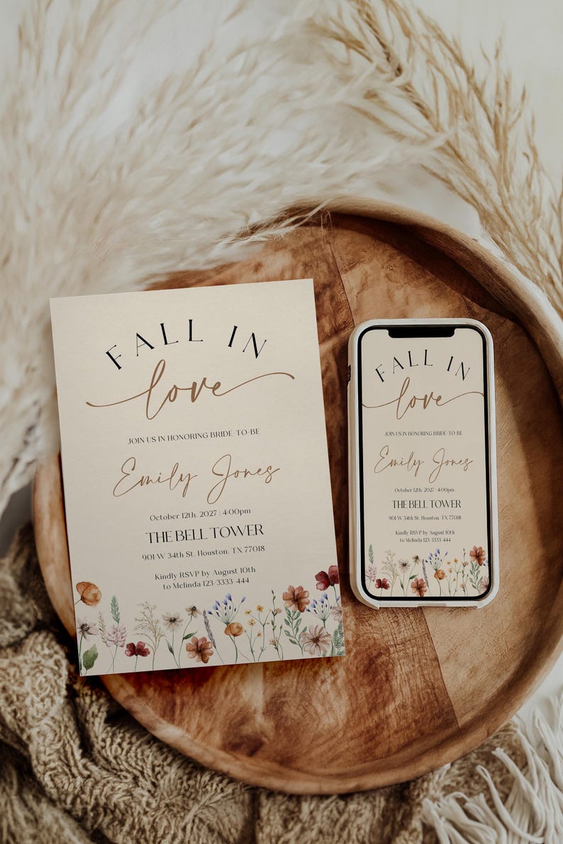 Fall in Love" bridal shower invitation with modern calligraphy, autumn wildflowers border, and minimalist neutral background.
