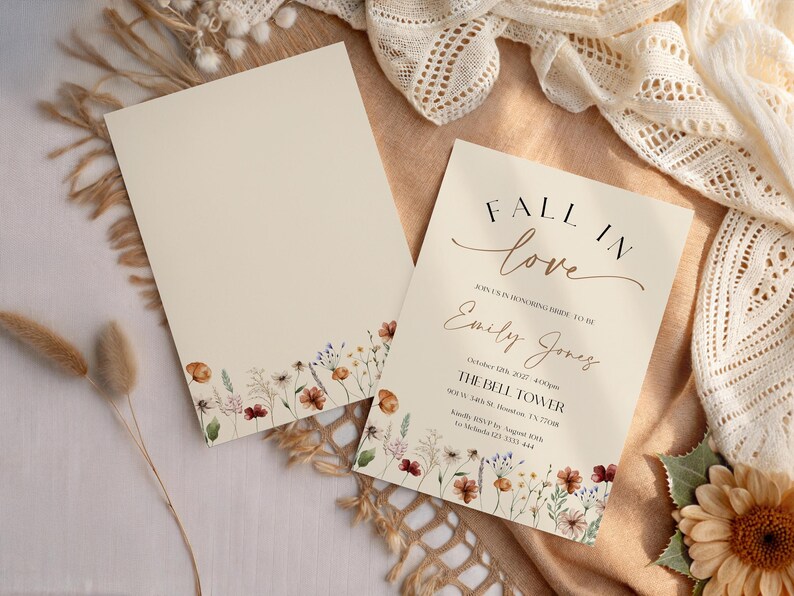 Fall in Love" bridal shower invitation with modern calligraphy, autumn wildflowers border, and minimalist neutral background.