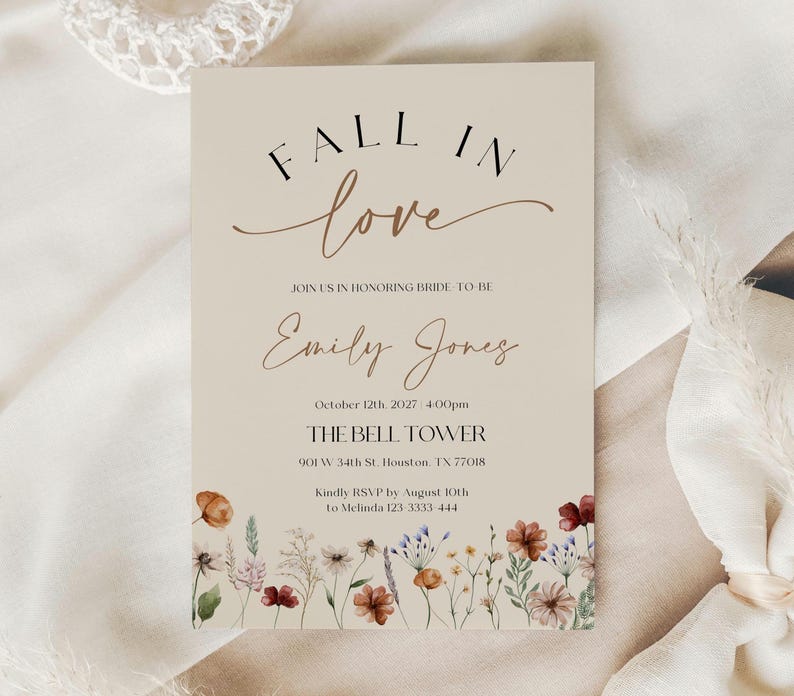 Fall in Love" bridal shower invitation with modern calligraphy, autumn wildflowers border, and minimalist neutral background.