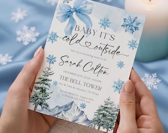 May include: A baby shower invitation with a winter theme. The invitation features a watercolor design with snowflakes, pine trees, and a blue bow. The text reads "Baby it's cold outside" and includes event details for Sarah Cotton's baby shower.