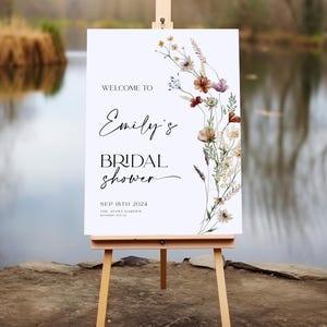 Bridal shower welcome sign template with boho watercolor wildflowers in warm earthy tones, featuring elegant mix of script and serif fonts on a clean white background, fully editable in Canva.