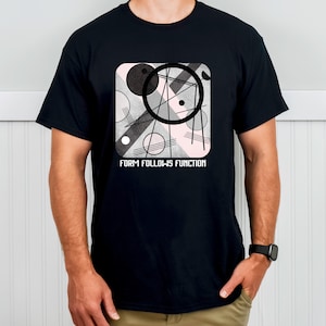 Könnte beinhalten: Schwarzes T-Shirt mit einem abstrakten geometrischen Design in Schwarz, Weiß und Rosa, mit dem Text "FORM FOLLOWS FUNCTION". Das Design umfasst Kreise, Linien und Formen. Das T-Shirt ist kurzärmelig.