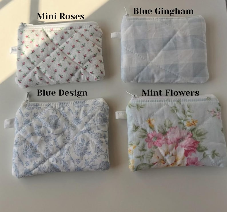 May include: Four small, quilted fabric pouches with zippers. The pouches feature different patterns: mini roses, blue gingham, blue design, and mint flowers. Each pouch has a small fabric loop attached to the zipper.