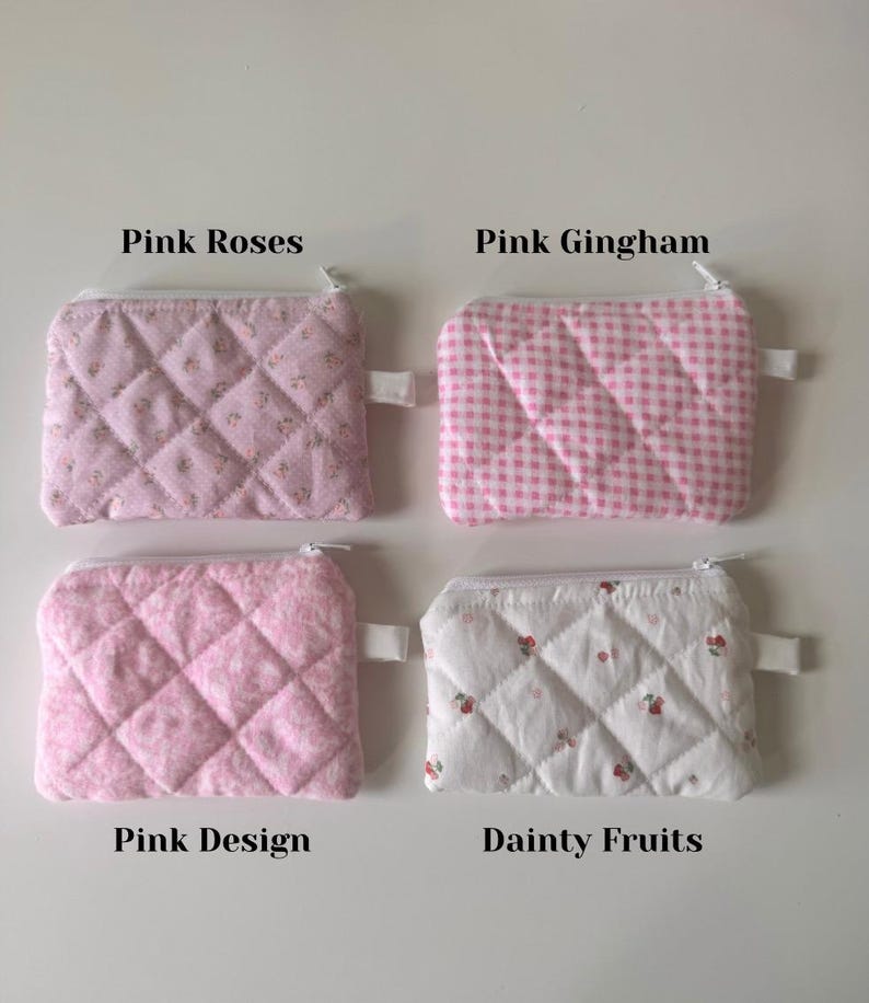 May include: Four quilted zipper pouches with different pink and white patterns. The pouches are labeled "Pink Roses", "Pink Gingham", "Pink Design", and "Dainty Fruits".