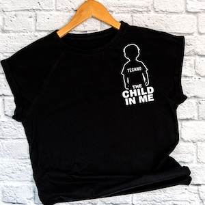 May include: Black t-shirt with a white silhouette of a child and the text "Techno The Child In Me"