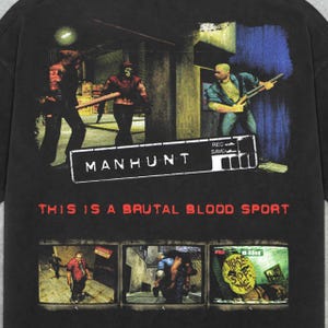 Peut inclure: T-shirt noir avec un graphique du jeu vid&eacute;o Manhunt. Le graphique pr&eacute;sente une sc&egrave;ne du jeu avec trois personnages et le texte "This is a brutal blood sport".