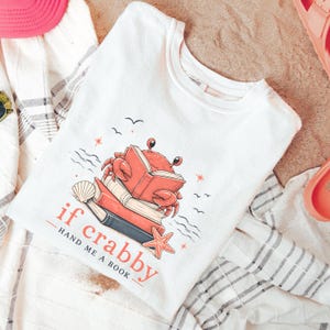 Trendy summer reading shirt for women featuring coastal crab and stacked book artwork