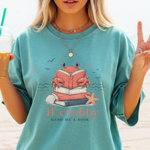 Beach themed book lover graphic tee with coral crab illustration and seashell accents