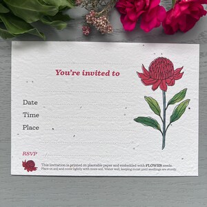 May include: A plantable invitation with a red flower illustration. The text "You're invited to" is at the top, with spaces for date, time, and place. The RSVP section includes instructions for planting the paper and growing flowers.