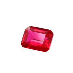 May include: A deep red gemstone with a rectangular emerald cut.