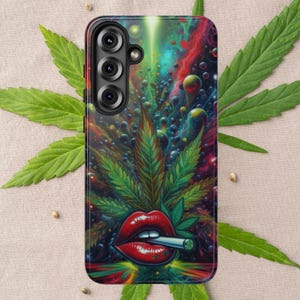 Könnte beinhalten: Eine Handyhülle mit einem lebendigen, psychedelischen Design. Die Hülle zeigt ein großes Cannabisblatt, rote Lippen, die eine brennende Zigarette halten, und einen farbenfrohen kosmischen Hintergrund. Die Hülle hat ein schwarzes Kameramodul.