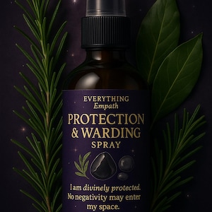Puede incluir: Una botella de spray de vidrio ámbar oscuro con una tapa negra, etiquetada como "PROTECTION & WARDING SPRAY". La etiqueta es morada con texto blanco y un gráfico de piedras negras. El romero verde y las hojas de laurel enmarcan la botella.