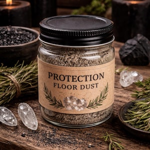 May include: A glass jar with a black lid labeled "PROTECTION FLOOR DUST" sits on a wooden surface. The jar contains a light brown powder. The background includes lit candles, crystals, and sprigs of rosemary, creating a mystical aesthetic.